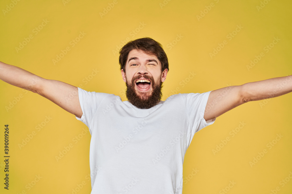 Bearded man white t-shirt emotions gestures with hands fun yellow background Bearded man white t-shirt emotions gestures with hands fun yellow background