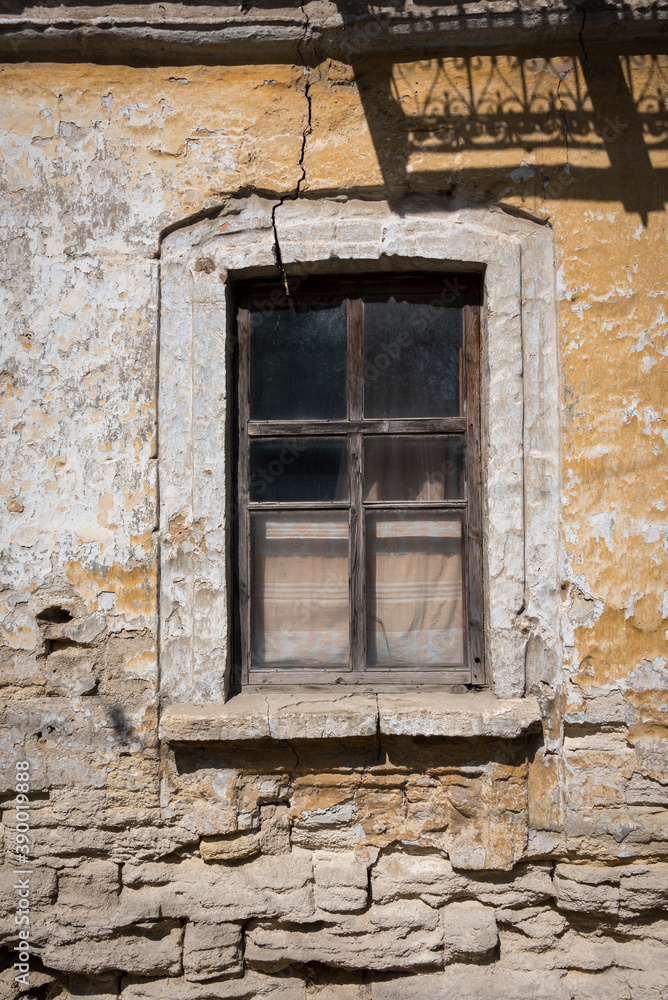Old window on cracked wall with peeling plaster Old window on cracked wall with peeling plaster