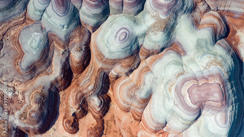 Aerial view mountains that look like they are from planet Mars. These round rock formations have blue, purple, red, and orange hues.