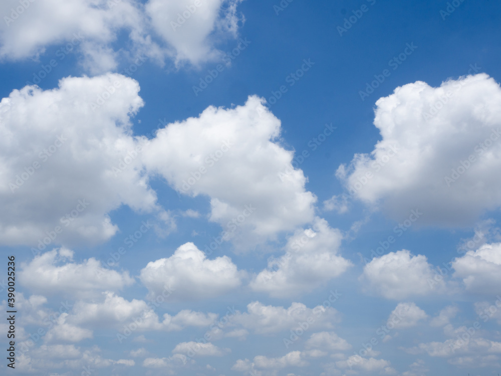 Clear blue sky background with white fluffy clouds.
