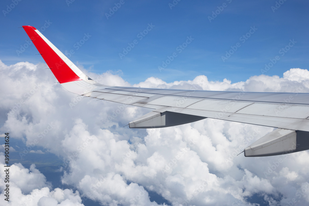 Fototapeta premium View of sky, cloud and wing of airplane from window