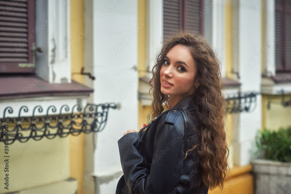 Young woman in a leather jacket on a walk in the city