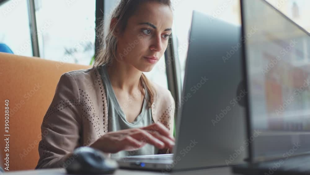 Young ptretty woman using portable laptop computer. Female freelancer or student typing keyboard, texting or coding, working at modern light workplace Young ptretty woman using portable laptop computer. Female freelancer or student typing keyboard, texting or coding, working at modern light workplace