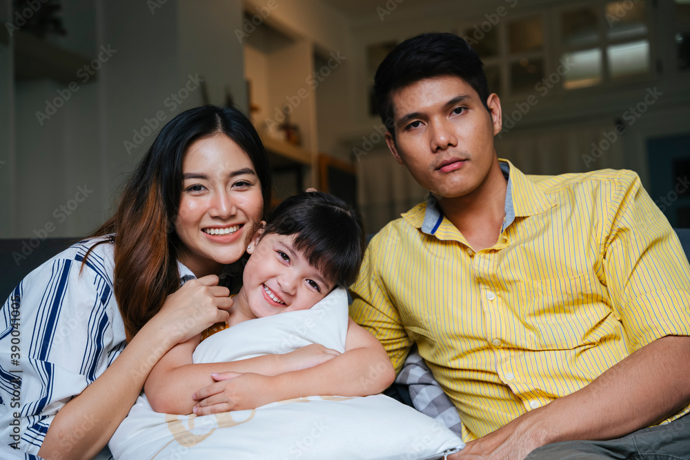 Asian family with mother, father, daughter in living room at home.