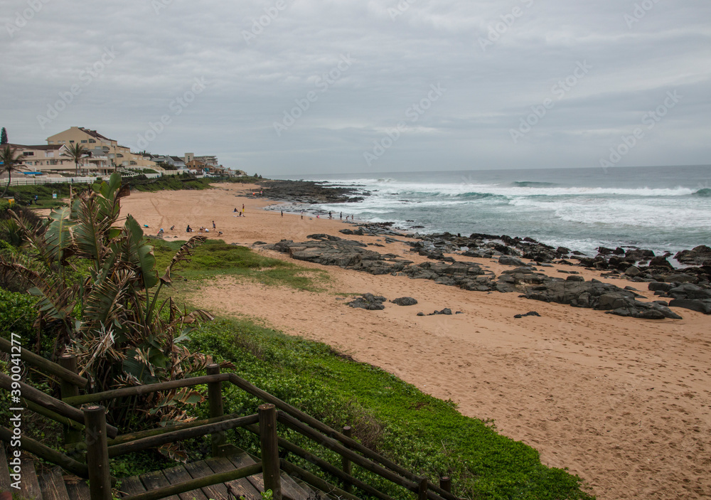 Wooden Stairway Leading Through Vegetation onto Rocky Beach
