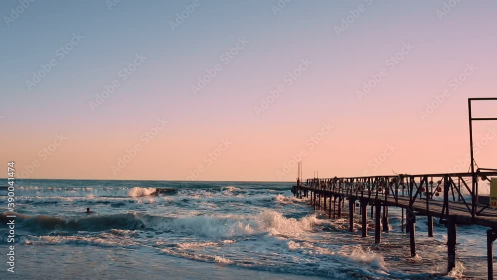 Landscape. View of the stormy sea and pier and cloudless sky. Evening. Violet colors Landscape. View of the stormy sea and pier and cloudless sky. Evening. Violet colors