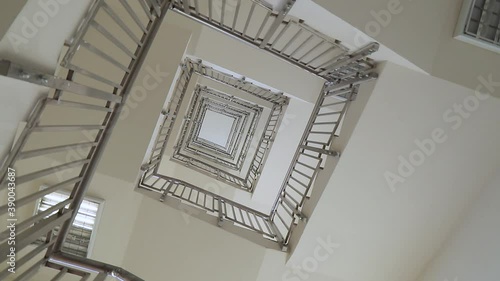spiral staircase in a multi-storey building. The camera shoots from below