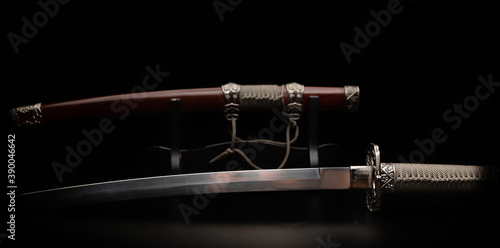 Beautiful katana sword with sheath and stand on a black background