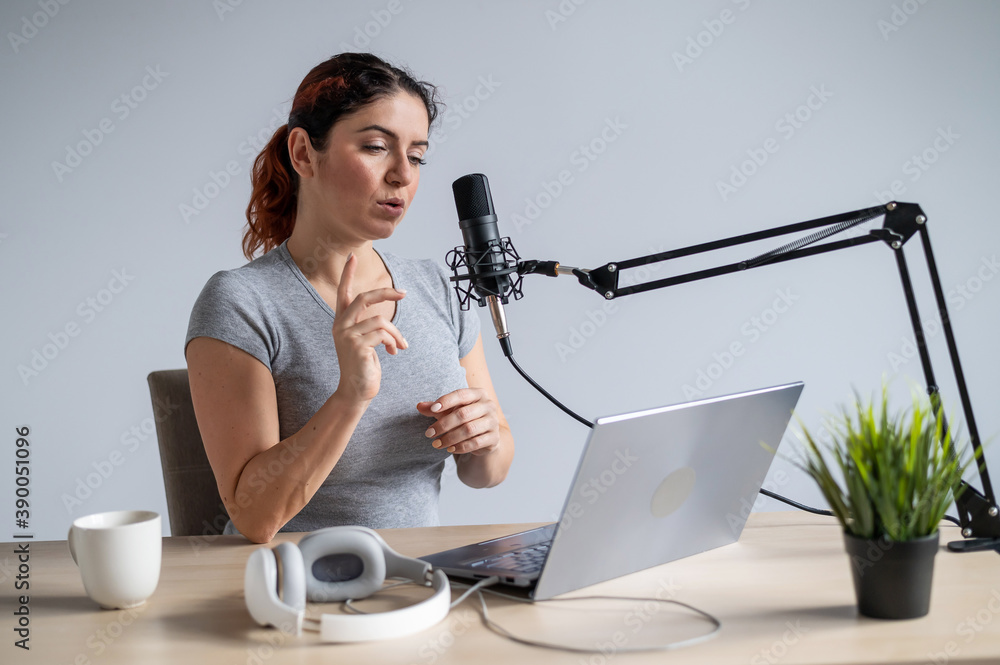 A charming woman radio host is broadcasting live on a laptop. Online radio concept A charming woman radio host is broadcasting live on a laptop. Online radio concept