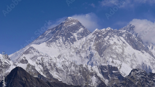 Panorama view of majestic Mount Everest (summit 8,848 m) with adjacent mountains Lhotse and Nuptse from Renjo La pass, Sagarmatha National Park, Nepal on sunny day with few clouds.