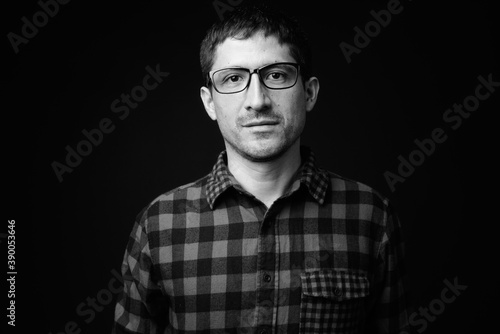 Portrait of Hispanic hipster man against black background
