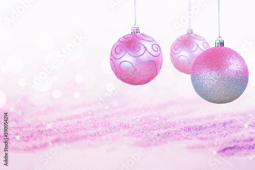 three pink christmas decorations on shiny defocus background
