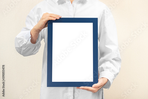 person in white coat holds empty mockup frame. doctor holds and shows the diploma