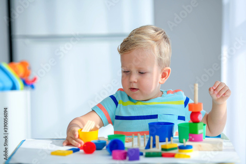 Little boy 2 years old is played with a colors toys. Educational logic toys for children. Montessori games for child development.