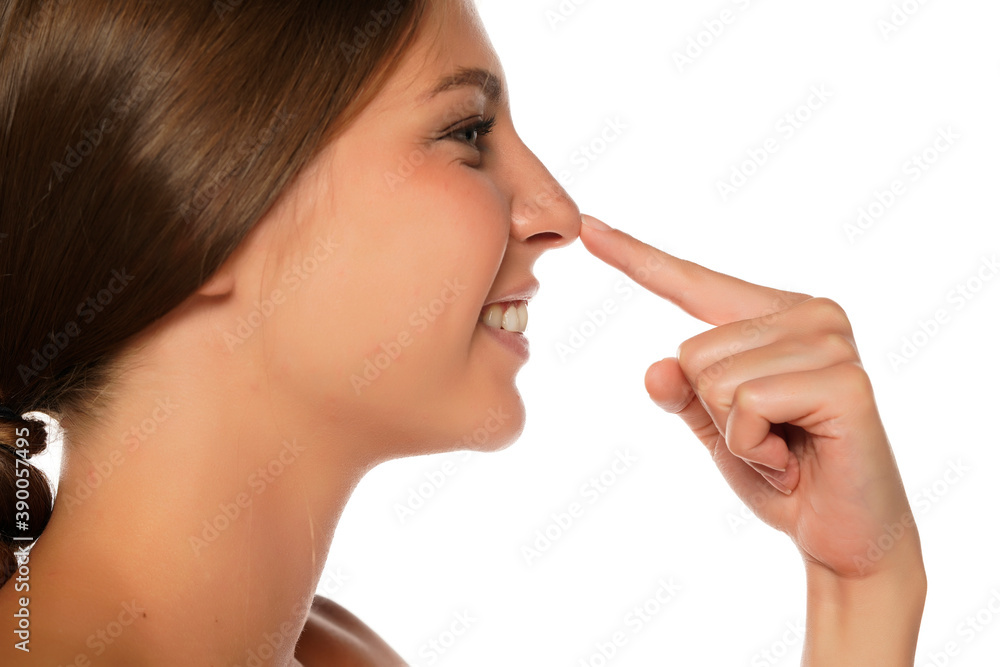 profile of young smiling woman touching her nose profile of young smiling woman touching her nose