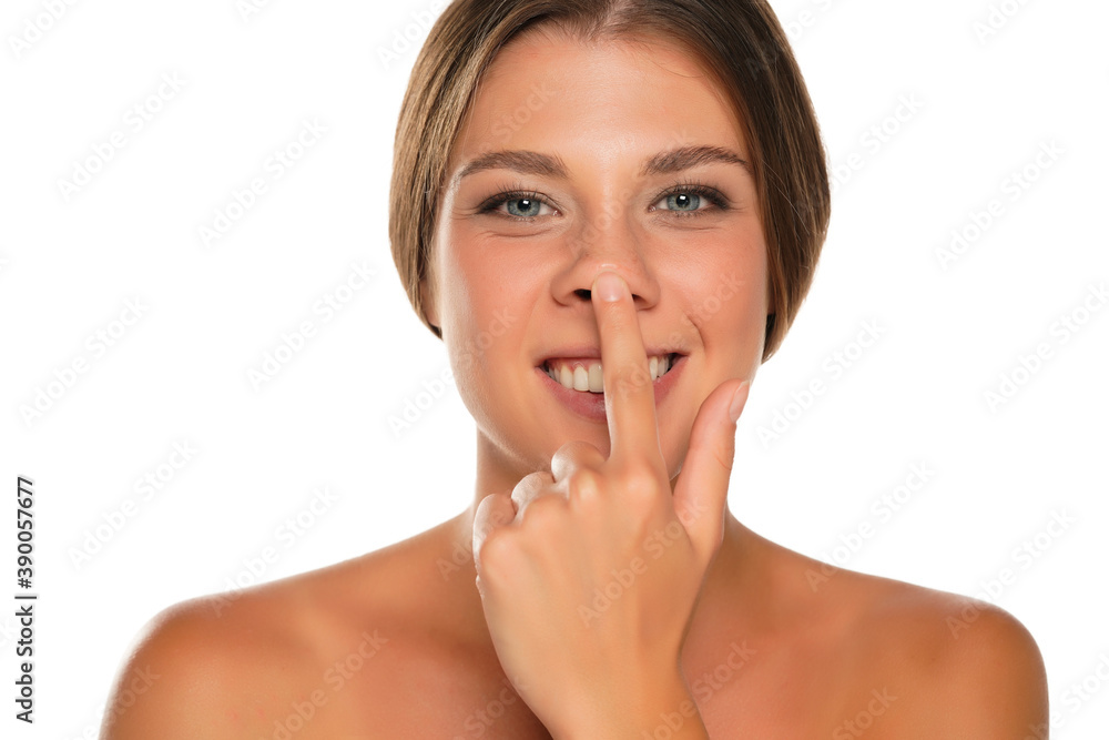 portrait of young smiling woman touches her nose portrait of young smiling woman touches her nose
