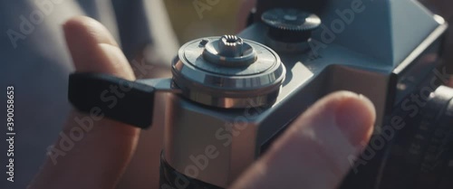 Photographer press trigger and reload analog camera with hand finger