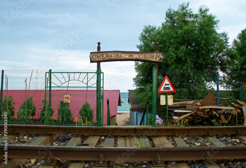 Fototapeta Naklejka Na Ścianę i Meble -  Acceso junto a la vía del tren a la playa de Olimp en Rumanía. Acceso a la playa con el cartel de 