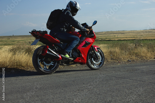 the young guy is sitting in a red motorcycle