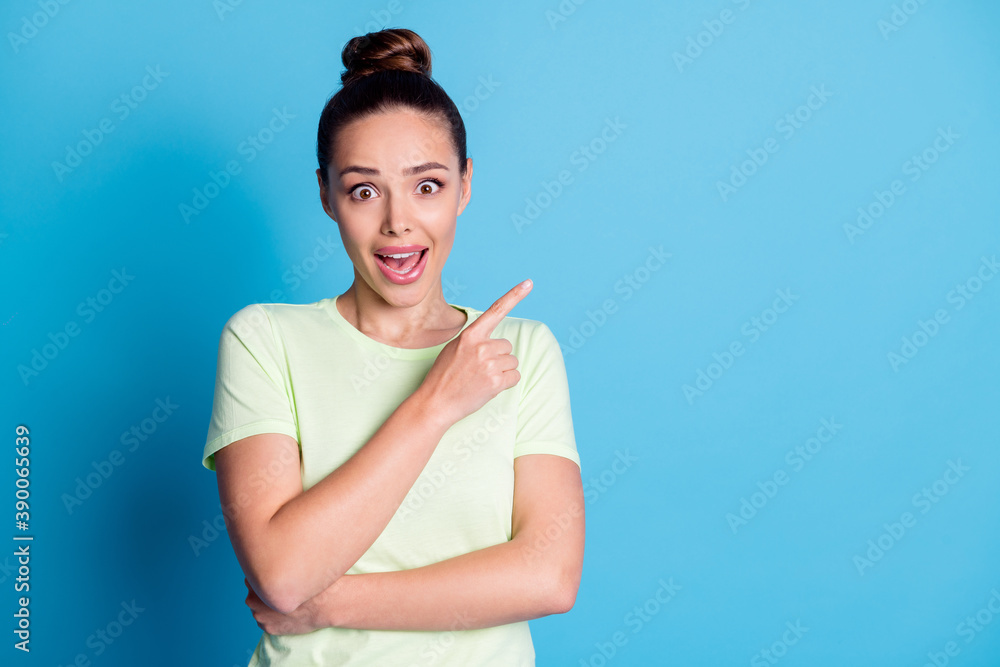 Photo of astonished girl point index finger copyspace isolated over blue pastel color background Photo of astonished girl point index finger copyspace isolated over blue pastel color background