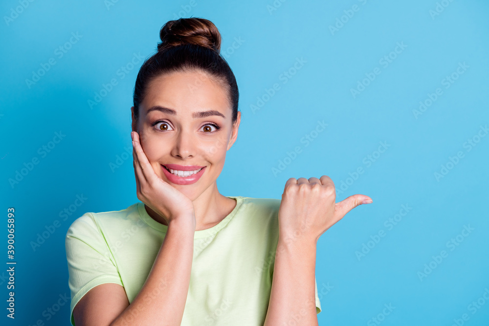 Photo of pretty excited lady point thumb finger empty space isolated over blue pastel color background Photo of pretty excited lady point thumb finger empty space isolated over blue pastel color background