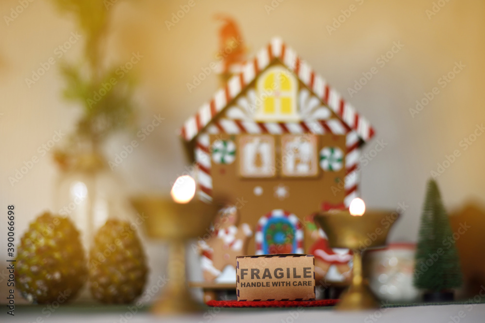 Beautiful out-of-focus Christmas background with house and gift: fragile, handle with care