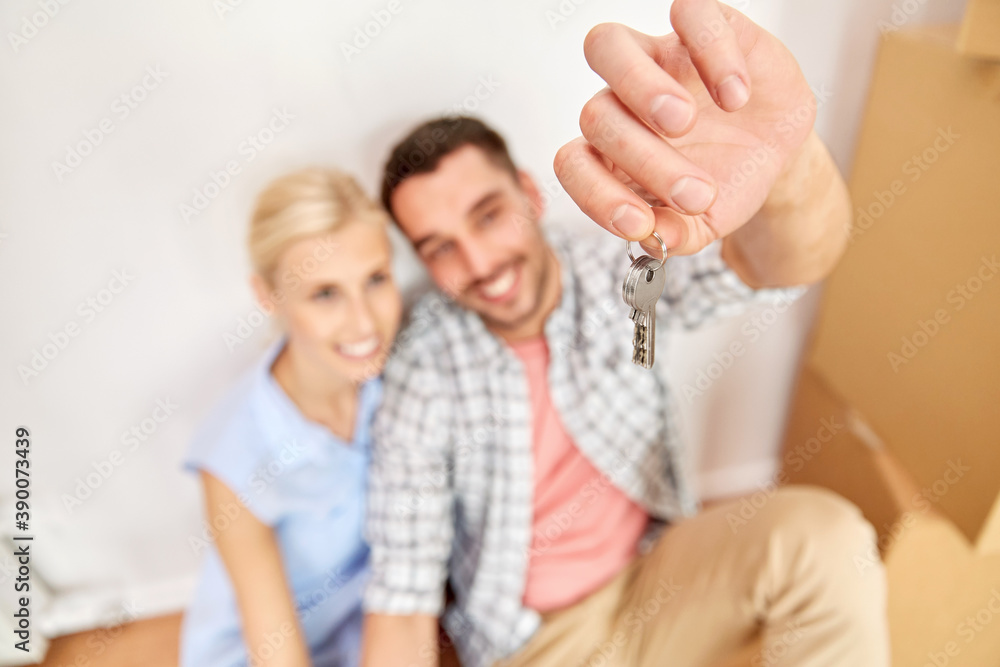 mortgage, people and real estate concept - happy couple with key and boxes moving to new home mortgage, people and real estate concept - happy couple with key and boxes moving to new home