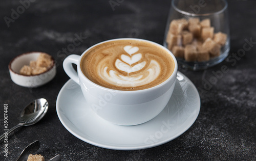 aromatic cappuccino in a white cup on a dark background.