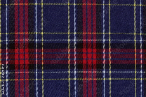 The texture of the woolen fabric in a check, reminiscent of tartan. Blue and red checkered fabric.