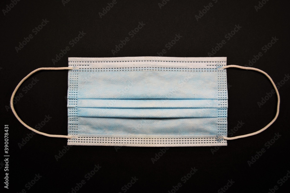 Surgical blue mask in a black background Surgical blue mask in a black background
