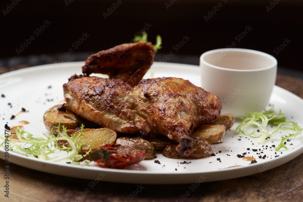 Grilled chicken Tabaka with baked potatoes and with sauce Grilled chicken Tabaka with baked potatoes and with sauce