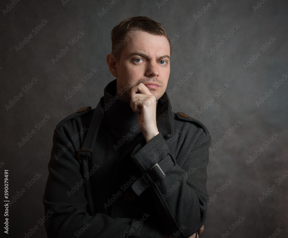 Young man in coat on dark background. Young man in coat on dark background.