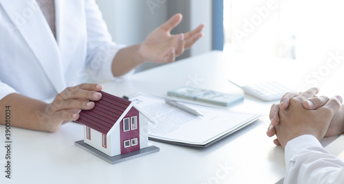 Home salesman explains the terms of buying a home to customers who need accommodation.