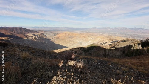 Panning view over Bingham Canyon Copper Mine in Utah looking towards Salt Lake City valley on sunny afternoon. photo