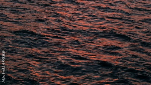 Slow motion of golden glittering sea surface, abstract background.