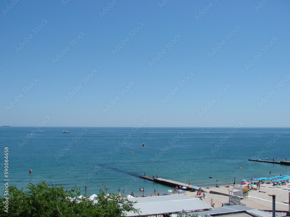 Top view of the famous beaches of Odessa surrounded by the calm blue of the Black Sea on a warm sunny day.