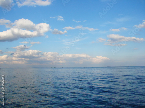 Picture of rainbow colors of the sunset reflected on the water surface of the endless blue sea.