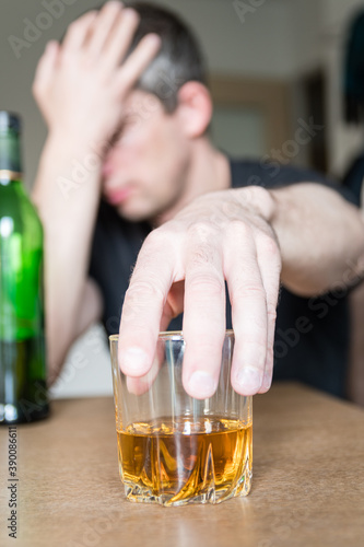 Homme alcoolique devant un verre d'alcool