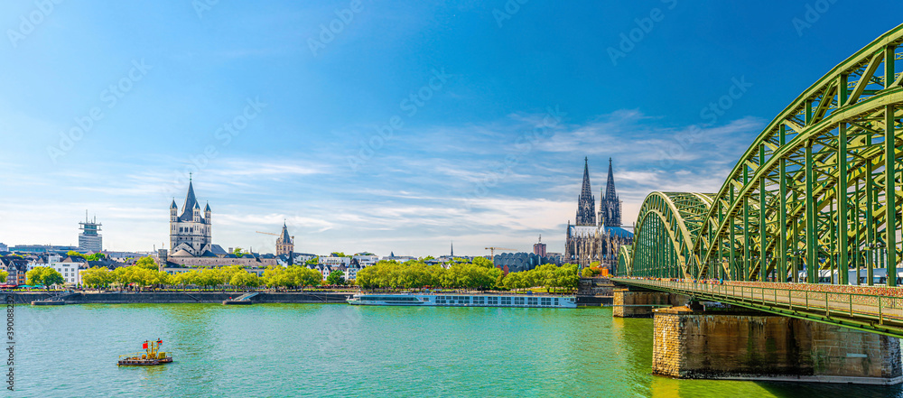 Panorama of Cologne city historical centre with Cologne Cathedral of Saint Peter, Great Saint Martin Roman Catholic Church buildings and Hohenzollern Bridge across Rhine river. Cologne panoramic view