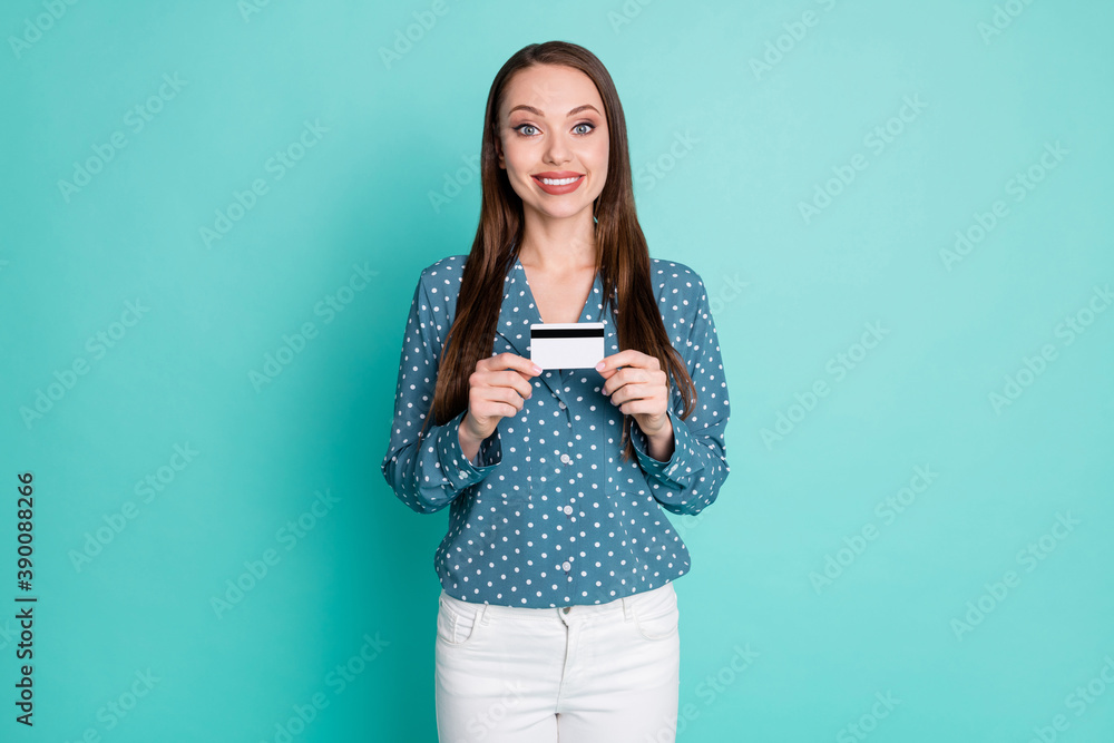 Photo of positive girl hold credit card wear blue blouse white pants isolated over teal color background Photo of positive girl hold credit card wear blue blouse white pants isolated over teal color background