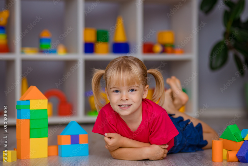 The girl plays with toys at home, in kindergarten or nursery. Child development. The girl plays with toys at home, in kindergarten or nursery. Child development.