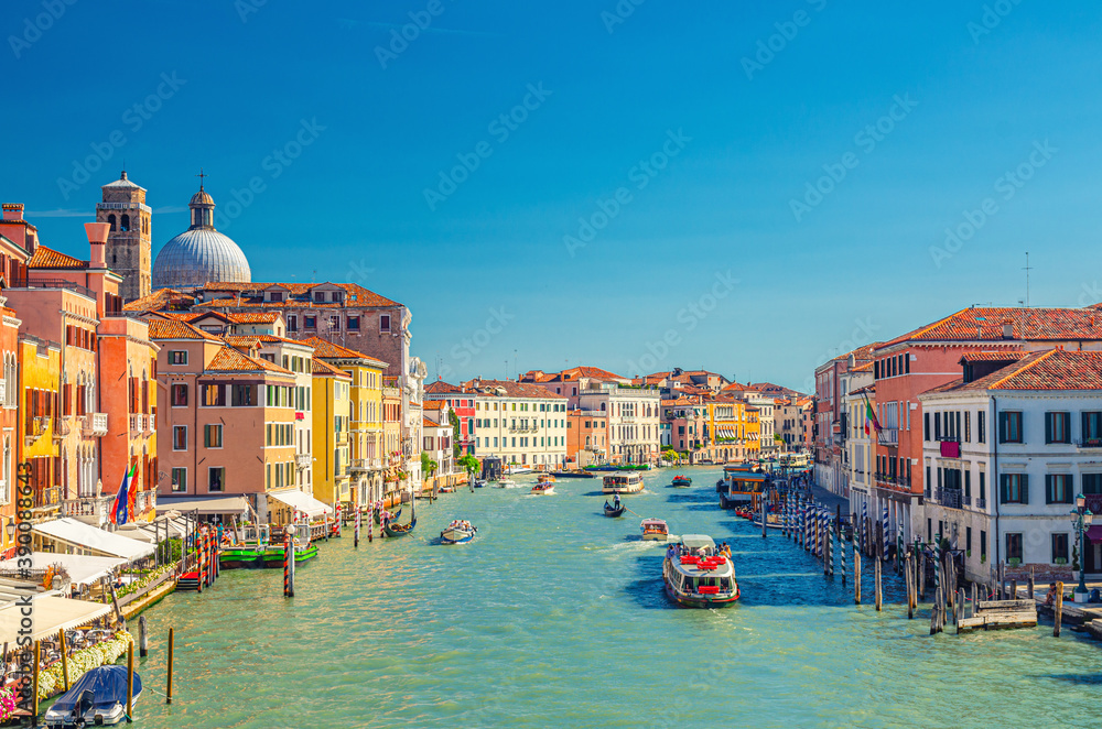 Venice cityscape with Grand Canal waterway. View from Scalzi bridge. Gondolas, boats, yachts, vaporettos docked and sailing Canal Grande. Venetian architecture buildings. Veneto Region, Italy.