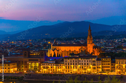 Top aerial evening view of Florence city with Basilica di Santa Croce, city buildings lights and hills at night dusk twilight, Tuscany, Italy