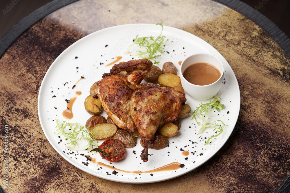 Grilled chicken Tabaka with baked potatoes and with sauce Grilled chicken Tabaka with baked potatoes and with sauce