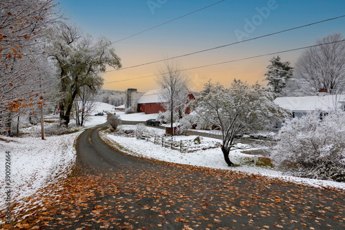 Walpole, New Hampshire, USA. 2020. Autmn leaves cover a highway and snow covers the countryside landscape in New Hampshire.