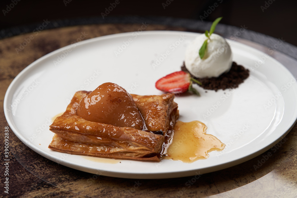 Puff pastry cake with caramel syrup, baked pear and ice cream Puff pastry cake with caramel syrup, baked pear and ice cream