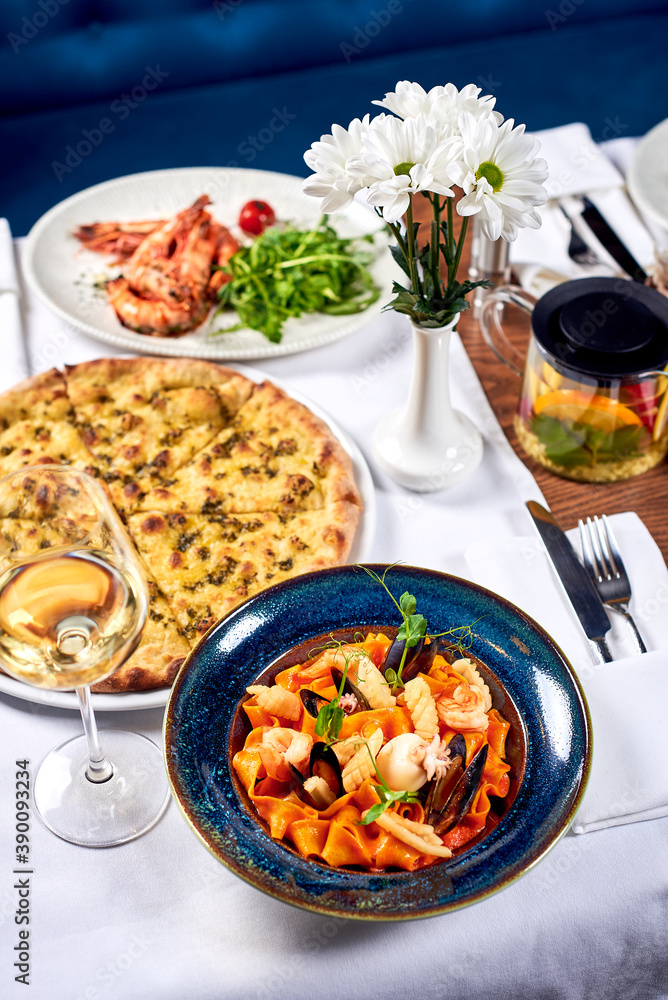 Pasta, pizza and fried shrimp on a table.