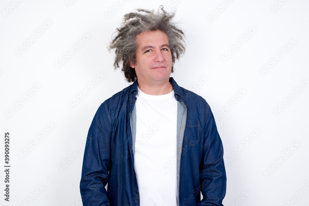 Happy Handsome middle aged Caucasian man with afro gray hair, against white wall, looking at camera with charming cute smile. Happy Handsome middle aged Caucasian man with afro gray hair, against white wall, looking at camera with charming cute smile.