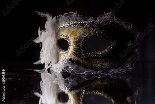 Carnival venetian masks on black surface, low key image, directed light, selective focus. © Milton Buzon