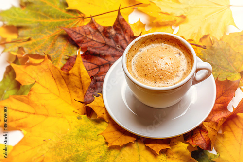 Coffee in a cup on a background of autumn leaves.